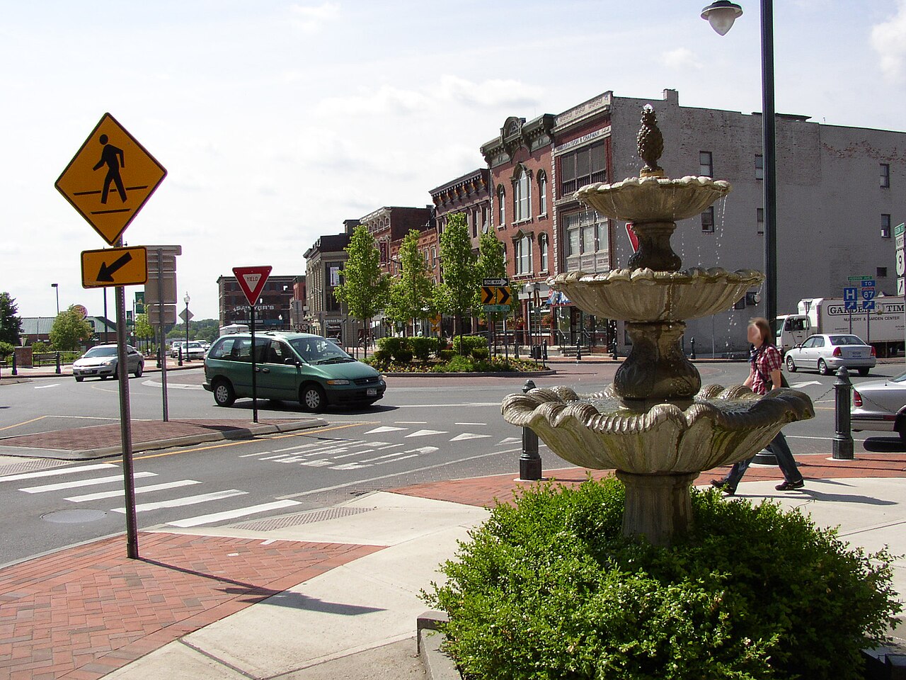 Fountain and historic downtown buildings at Centennial Circle in Glens Falls